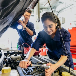 Female apprentice fixing car